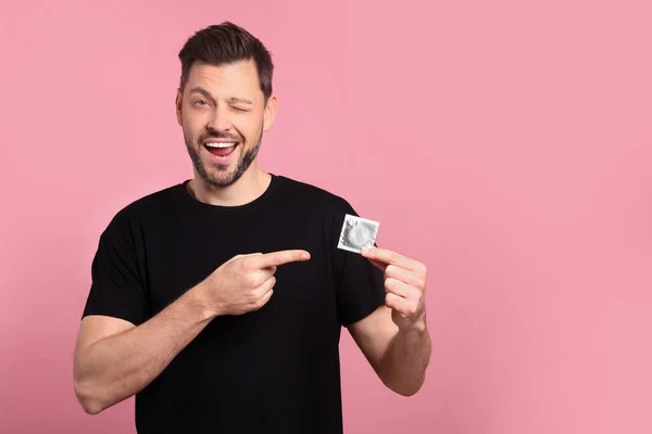 Homem Feliz Segurando Preservativo Fundo Rosa Espaço Para Texto — Fotografia de Stock