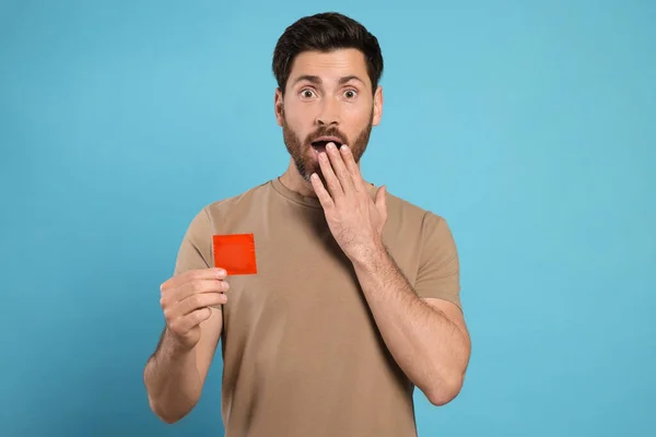 Känslomässig Man Håller Kondom Ljusblå Bakgrund Säkert Sex — Stockfoto
