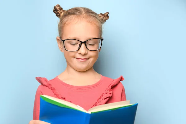 Aranyos Kislány Szemüvegben Tankönyvet Olvas Világoskék Háttérrel Szöveg Helye — Stock Fotó