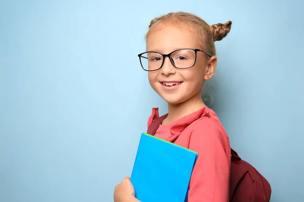 バックパック ライトブルーの背景に教科書を持つかわいい女の子 テキストのスペース — ストック写真