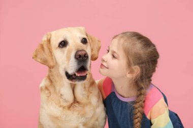 Pembe arka planda sevimli köpeğiyle genç bir kız.