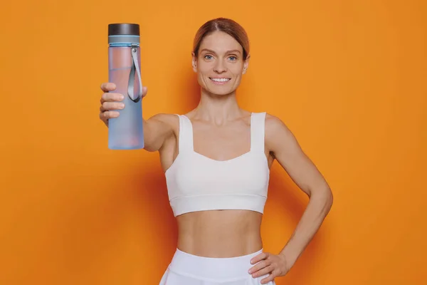 Sportvrouw Met Flesje Water Oranje Achtergrond — Stockfoto