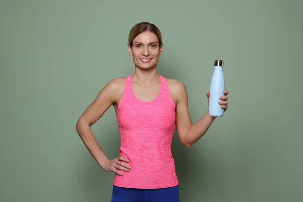 带着绿色背景热瓶的女运动员 — 图库照片
