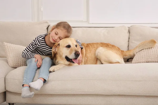 Evdeki kanepede sevimli köpeğiyle genç bir kız.