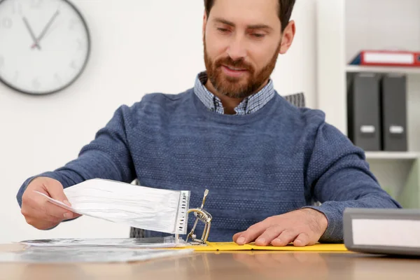 ビジネスマンはオフィスの木製テーブルのファイルフォルダに文書を置く — ストック写真