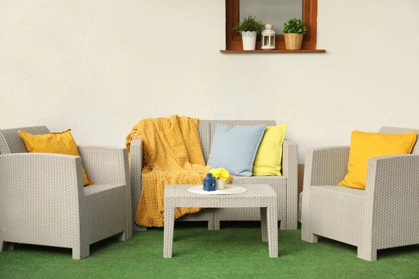 stock image Beautiful rattan garden furniture, soft pillows, blanket and yellow chrysanthemum flowers outdoors