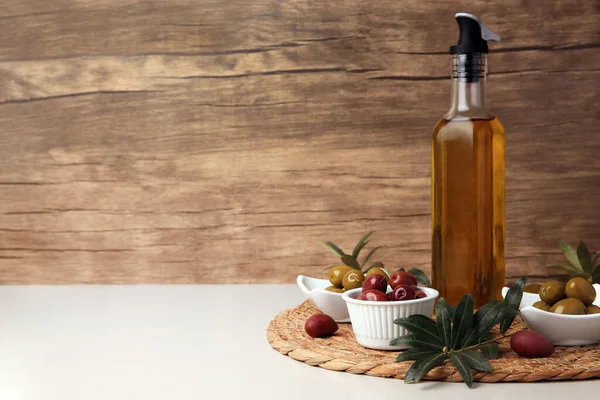 米色桌子上的油瓶 橄榄和树枝 文字空间 — 图库照片