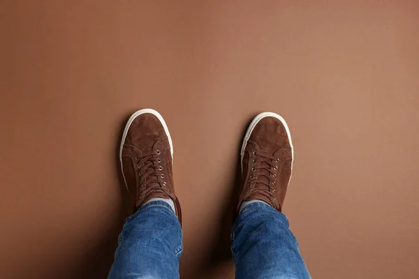 Man Stylish Sneakers Standing Brown Background Top View — Stock Photo, Image