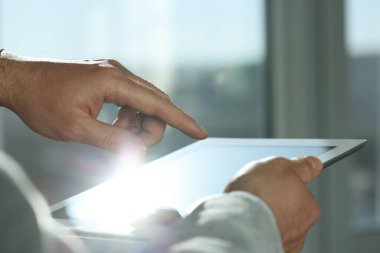 Kapalı alanda yeni tablet kullanan adamın yakın görüntüsü