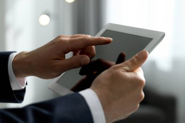 Kapalı alanda yeni tablet kullanan adamın yakın görüntüsü