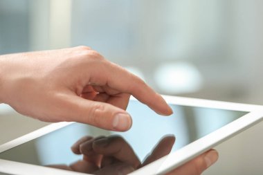 Kapalı alanda yeni tablet kullanan adamın yakın görüntüsü