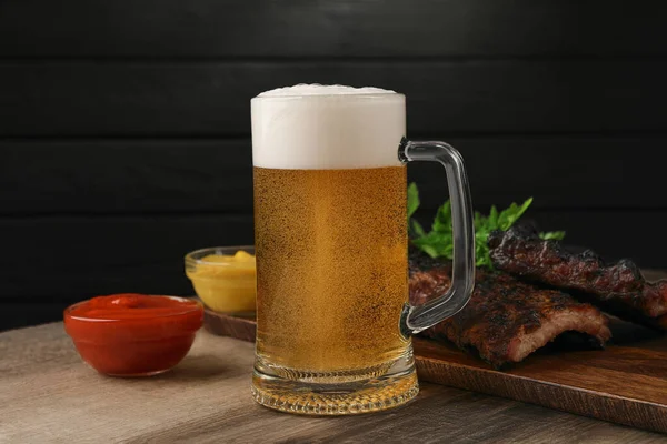 Caneca Com Cerveja Deliciosas Costelas Grelhadas Molhos Mesa Madeira — Fotografia de Stock