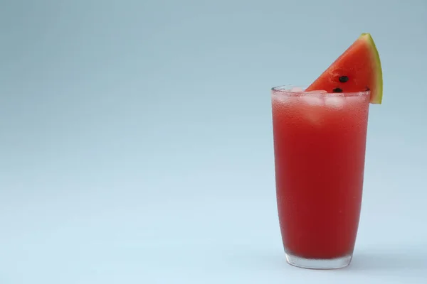 Läcker Dryck Med Isbitar Och Bit Färsk Vattenmelon Ljusblå Bakgrund — Stockfoto