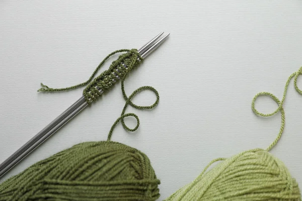 柔らかい緑の糸 編み物 薄い背景の金属針 フラットレイ — ストック写真