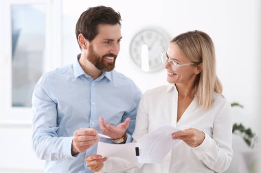 Ofiste belgelerle çalışan mutlu iş adamları