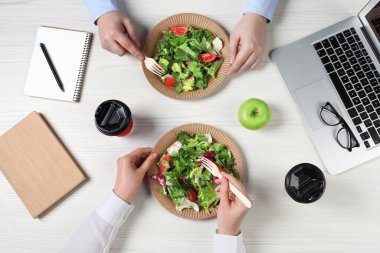 Ofis çalışanları iş yerinde öğle yemeği yiyor.