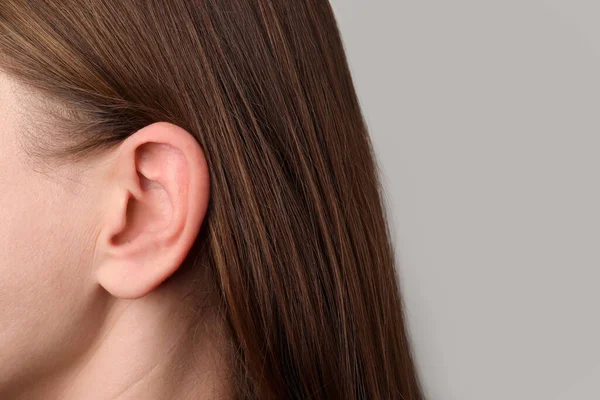 Nahaufnahme Einer Frau Vor Hellgrauem Hintergrund Fokus Auf Das Ohr — Stockfoto