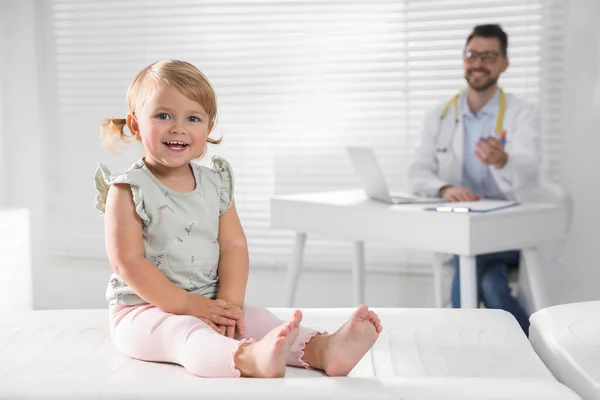 클리닉에서 수술대에서 일하는 소아과 의사는 귀여운 아기에게 — 스톡 사진
