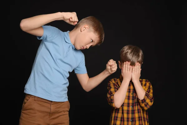 男の子とともにClenched拳いじめ怖がって子供に黒の背景 — ストック写真