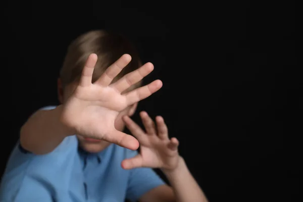 stock image Boy making stop gesture against black background, focus on hands and space for text. Children's bullying