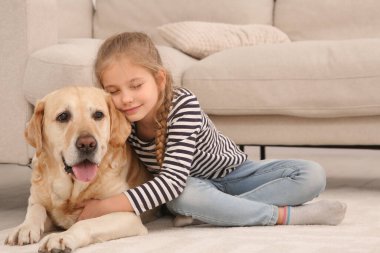 Evde sevimli köpeğiyle yerde yatan genç bir kız.
