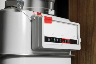 Beyaz duvarın yanındaki elektrik sayacı, yakın plan. Gaz Ölçüm Cihazı