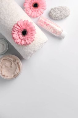 Farklı spa ürünleri ve güzel çiçeklerle bembeyaz masa üzerinde düz bir kompozisyon vardı. Metin için boşluk