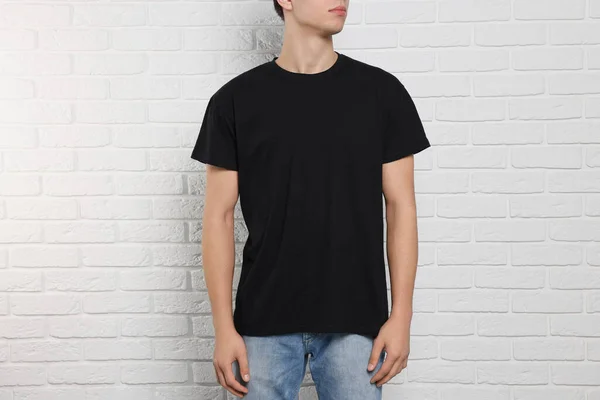 Man Met Zwart Shirt Buurt Van Witte Bakstenen Muur Close — Stockfoto