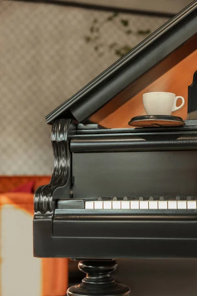カフェで黒グランドピアノのコースター付きカップ — ストック写真