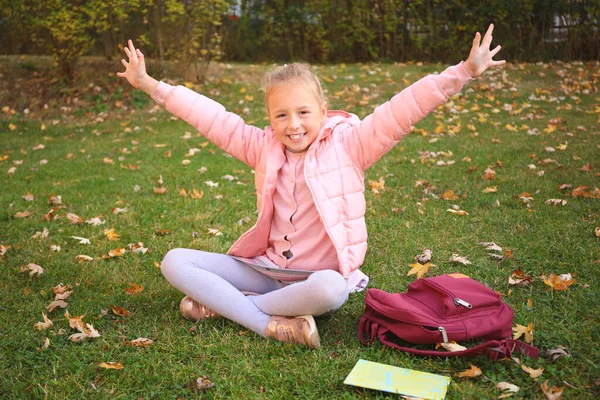 Nettes Kleines Mädchen Mit Lesebuch Und Rucksack Auf Grünem Gras — Stockfoto