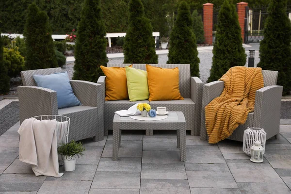 stock image Beautiful rattan garden furniture, soft pillows and different decor elements in backyard