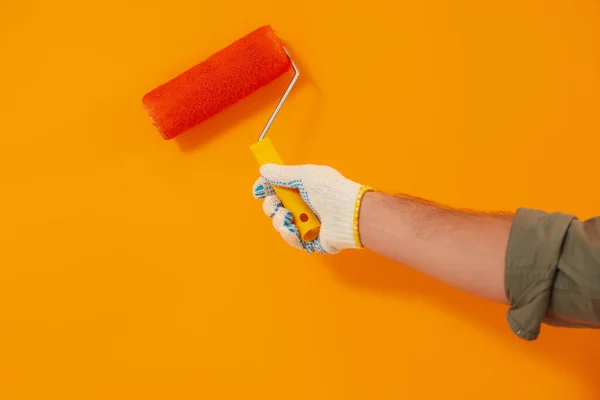 Designer Painting Orange Wall Roller Closeup — Zdjęcie stockowe