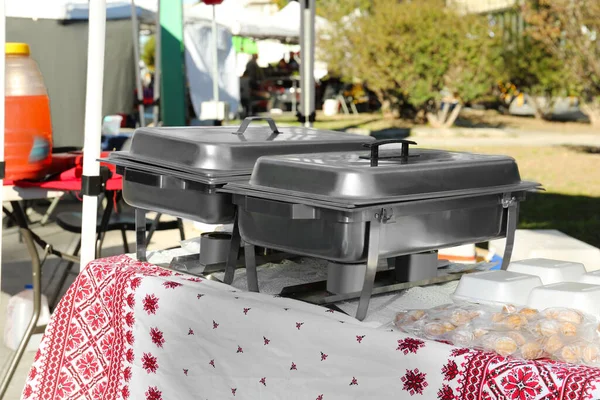 Gönüllü Yemek Dağıtımı Dışarıdaki Masada Lezzetli Yemekleri Olan Metal Isıtıcılar — Stok fotoğraf