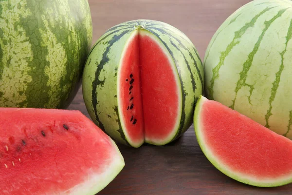 stock image Different delicious ripe watermelons on wooden table