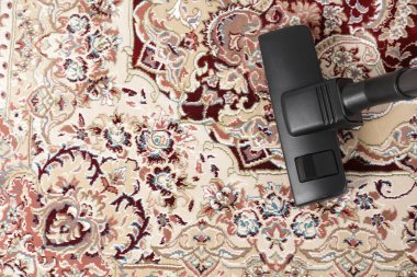 Modern elektrikli süpürgeyle süpürülen halı, üst manzara. Metin için boşluk