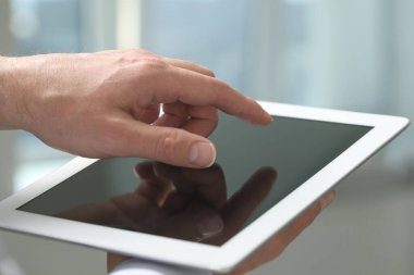 Kapalı alanda yeni tablet kullanan adamın yakın görüntüsü