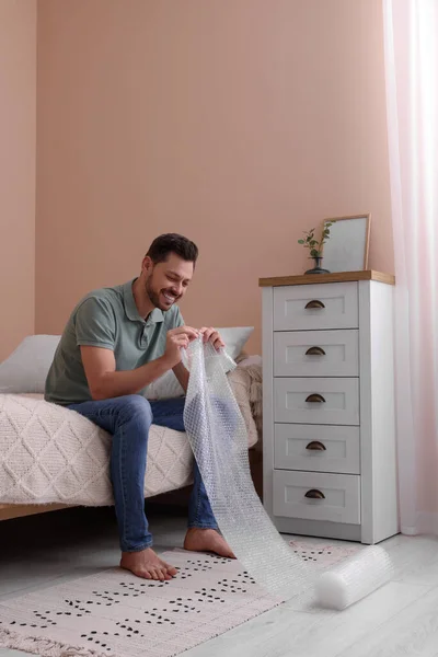 Man Popping Bubble Wrap Bedroom Home Stress Relief Stock Photo by