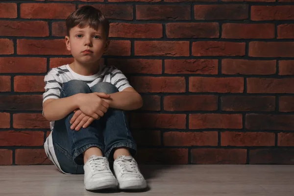 Malý Chlapec Sedí Podlaze Cihlové Zdi Prostor Pro Text Šikana — Stock fotografie