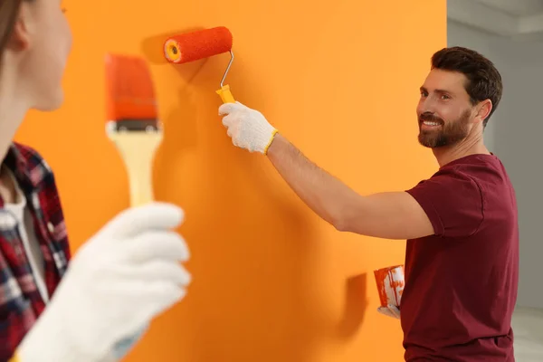 Man Painting Orange Wall Woman Brush Interior Design — Foto Stock