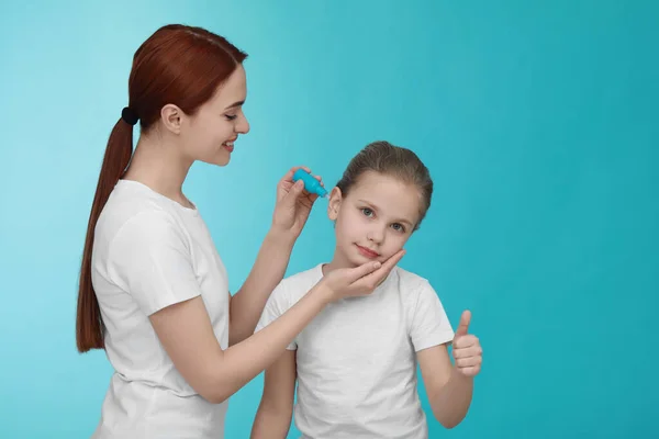 Madre Goteando Medicamentos Oído Hija Sobre Fondo Azul Claro Espacio — Foto de Stock