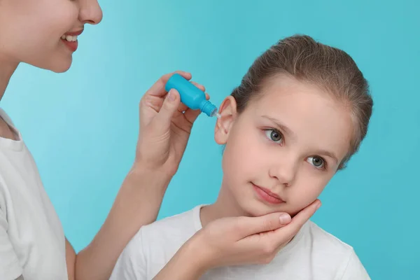 Mutter Tropft Ihrer Tochter Auf Hellblauem Hintergrund Medikamente Ins Ohr — Stockfoto