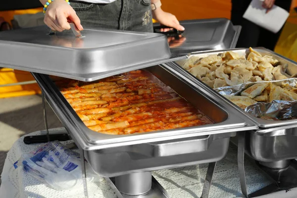 女志愿者从食品保温箱中分发美味的包菜 饺子和馅饼 — 图库照片