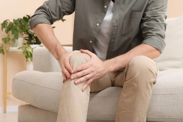 stock image Man suffering from pain in his leg at home, closeup. Arthritis symptoms