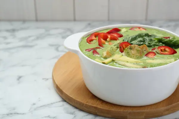 stock image Saucepan with delicious green curry chicken soup on white marble table. Space for text