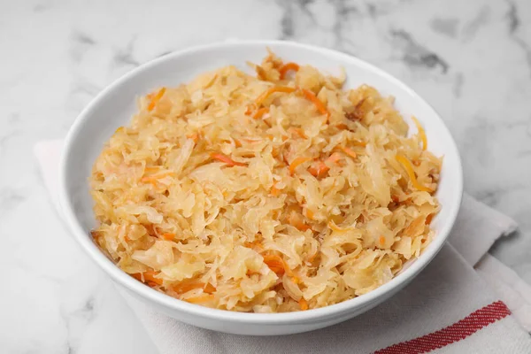 stock image Bowl with tasty sauerkraut on white marble table, closeup