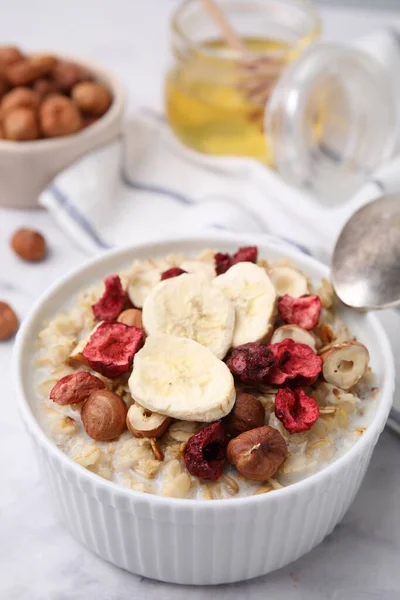 Delicious Oatmeal Freeze Dried Berries Banana Hazelnuts White Table Closeup — Stock Photo, Image