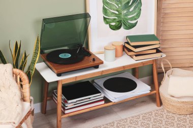 Samimi odadaki konsol masasında vinil plaklı şık bir pikap.