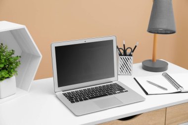 Cozy workplace with laptop and stationery on desk. Home office