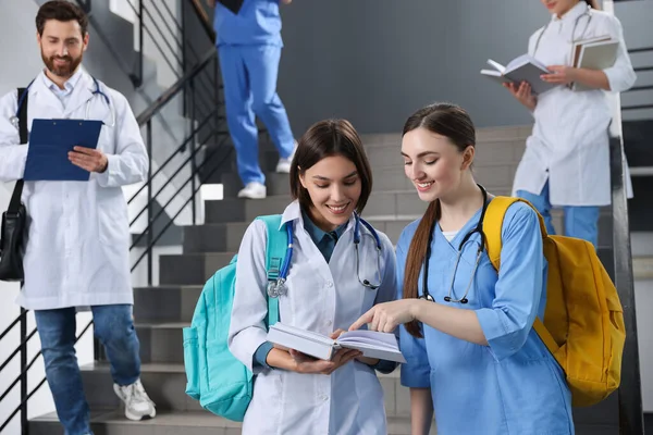 Medical students wearing uniforms on staircase in college, space for text