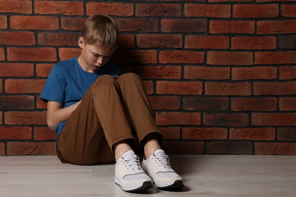 Upset Boy Sitting Floor Brick Wall Space Text Children Bullying — Foto Stock